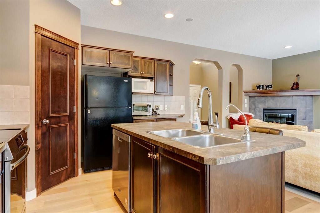 185 Brightonstone Landing Se, Calgary, AB - Indoor Photo Showing Kitchen With Fireplace With Double Sink