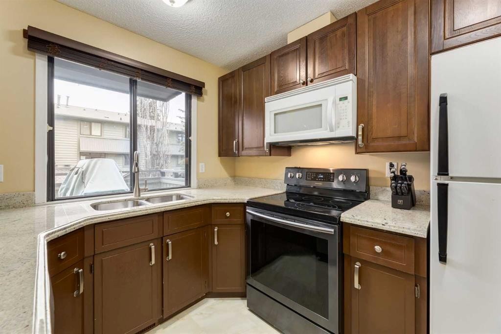 59-10030 Oakmoor Way Sw, Calgary, AB - Indoor Photo Showing Kitchen With Double Sink