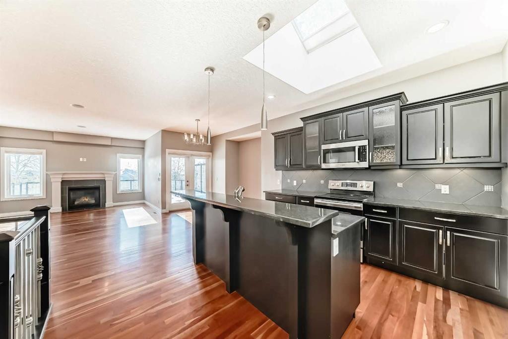 88 Sunset Circle, Cochrane, AB - Indoor Photo Showing Kitchen With Fireplace With Upgraded Kitchen