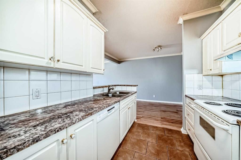 205-7 Lineham Avenue, Okotoks, AB - Indoor Photo Showing Kitchen With Double Sink
