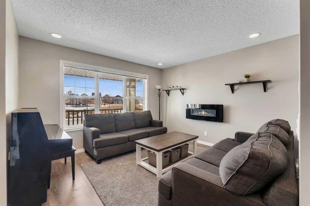 23 Copperpond Square Se, Calgary, AB - Indoor Photo Showing Living Room With Fireplace