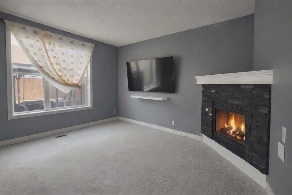 1580 New Brighton Drive Se, Calgary, AB - Indoor Photo Showing Living Room With Fireplace