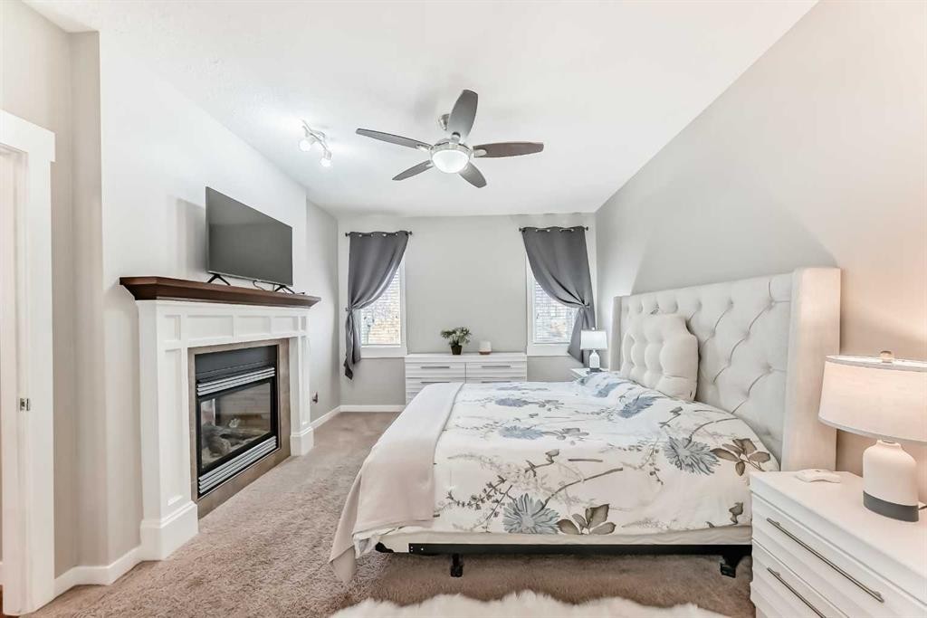 160 Sienna Passage, Chestermere, AB - Indoor Photo Showing Bedroom With Fireplace