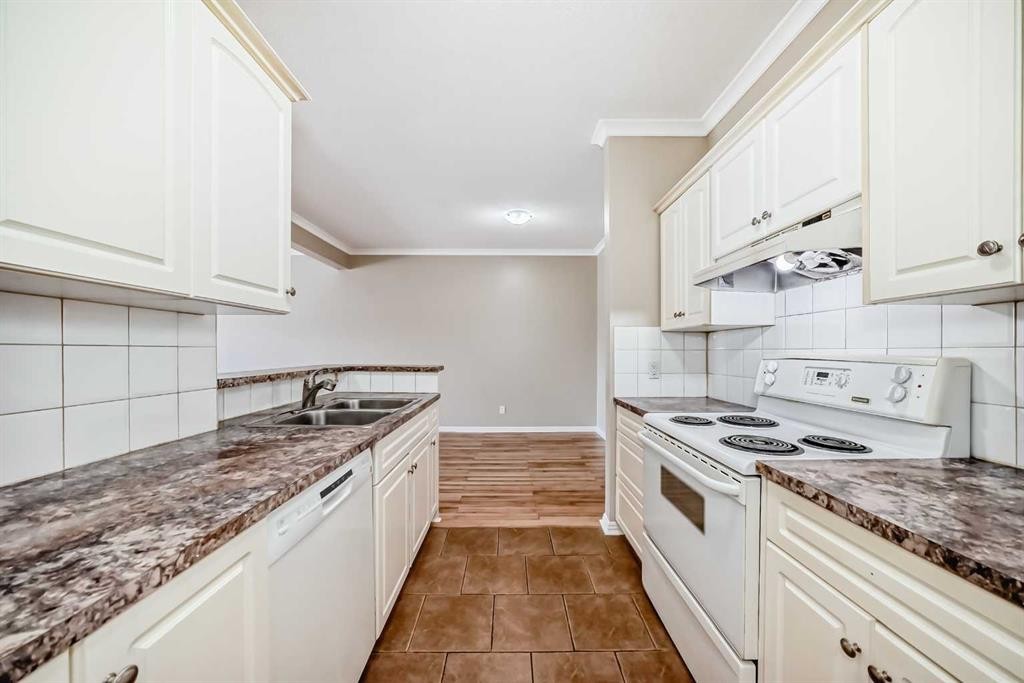 205-7 Lineham Avenue, Okotoks, AB - Indoor Photo Showing Kitchen With Double Sink