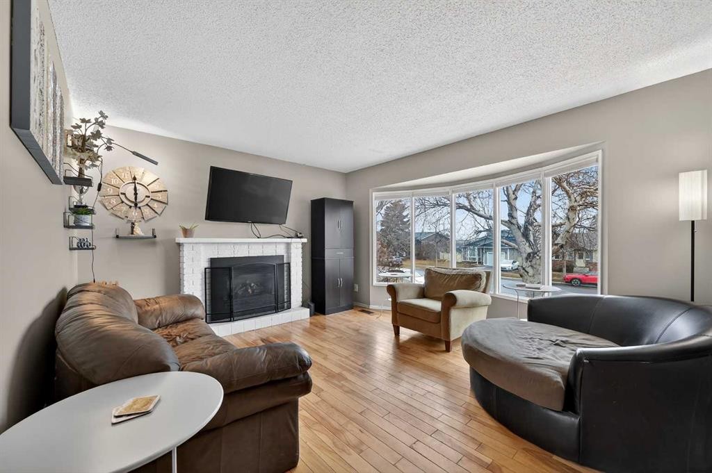 103 Macewan Drive Nw, Calgary, AB - Indoor Photo Showing Living Room With Fireplace