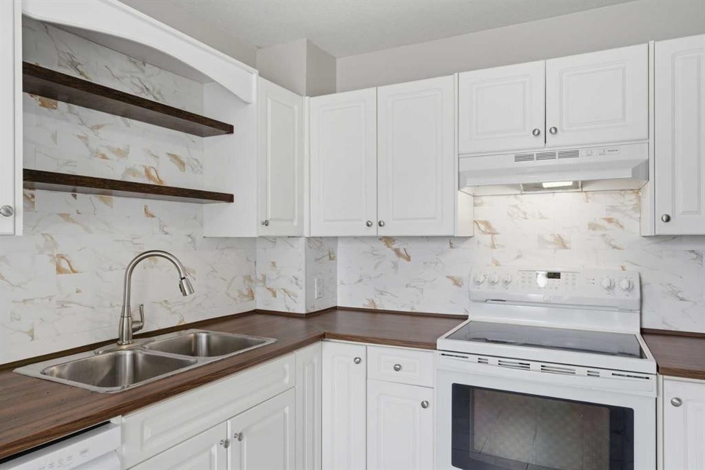 1-12 Silver Creek Boulevard Nw, Airdrie, AB - Indoor Photo Showing Kitchen With Double Sink