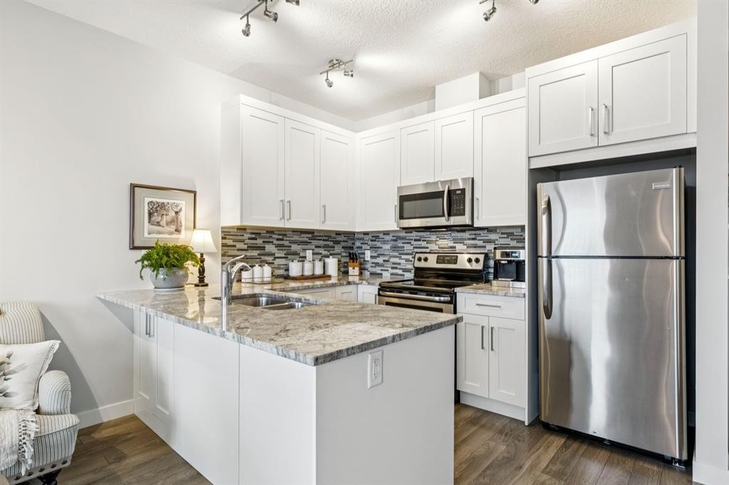 1502 Jumping Pound Common, Cochrane, AB - Indoor Photo Showing Kitchen With Stainless Steel Kitchen With Double Sink With Upgraded Kitchen