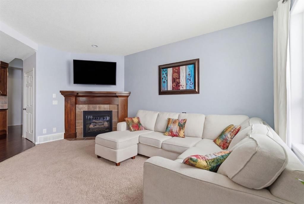 512 Panatella Square Nw, Calgary, AB - Indoor Photo Showing Living Room With Fireplace