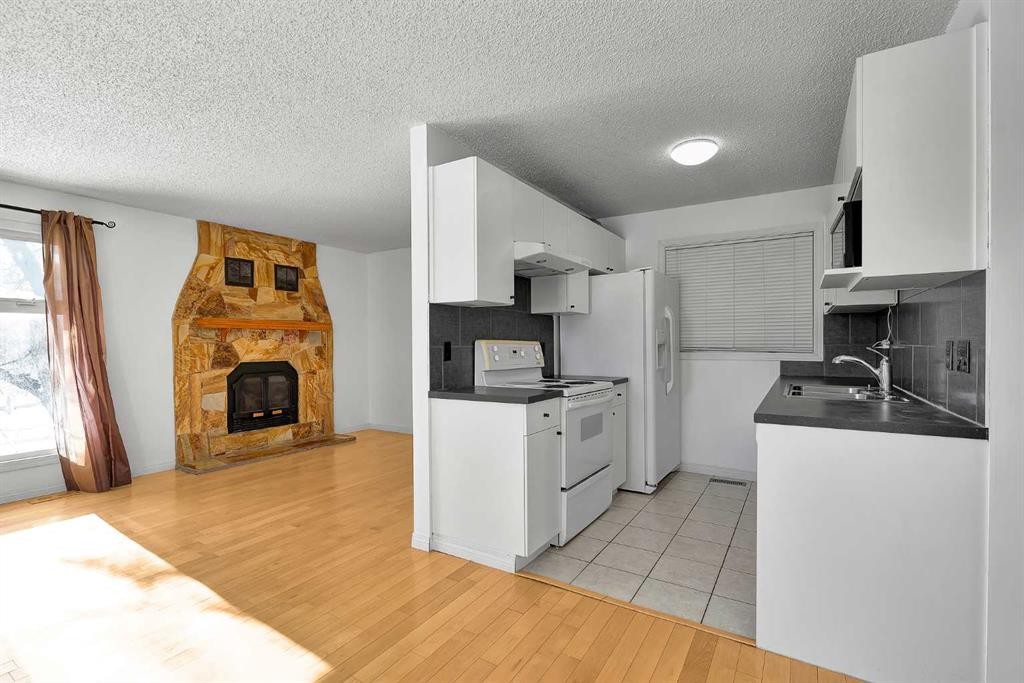 295 Edgepark Boulevard Nw, Calgary, AB - Indoor Photo Showing Kitchen With Fireplace With Double Sink
