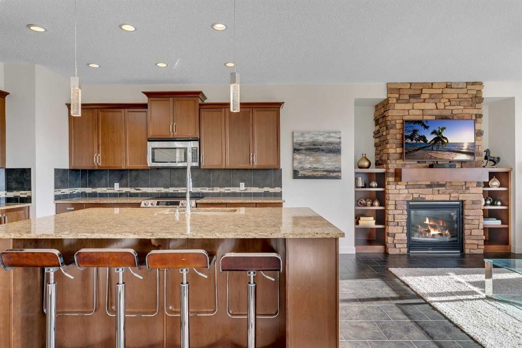 287 Sunset View, Cochrane, AB - Indoor Photo Showing Kitchen With Fireplace With Double Sink
