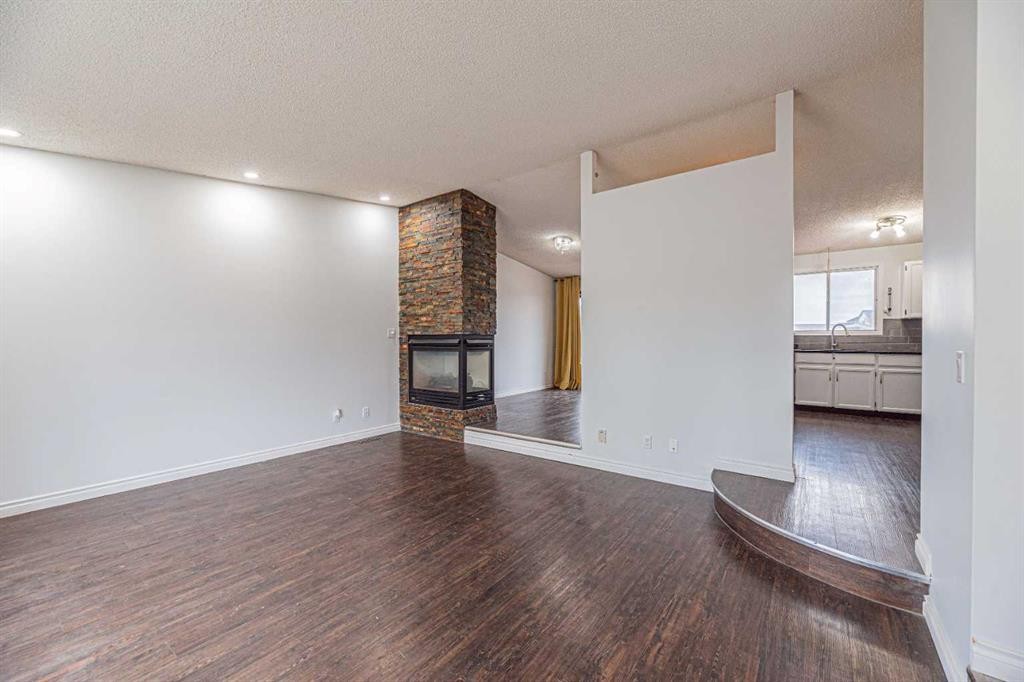64 Castledale Crescent Ne, Calgary, AB - Indoor Photo Showing Other Room With Fireplace