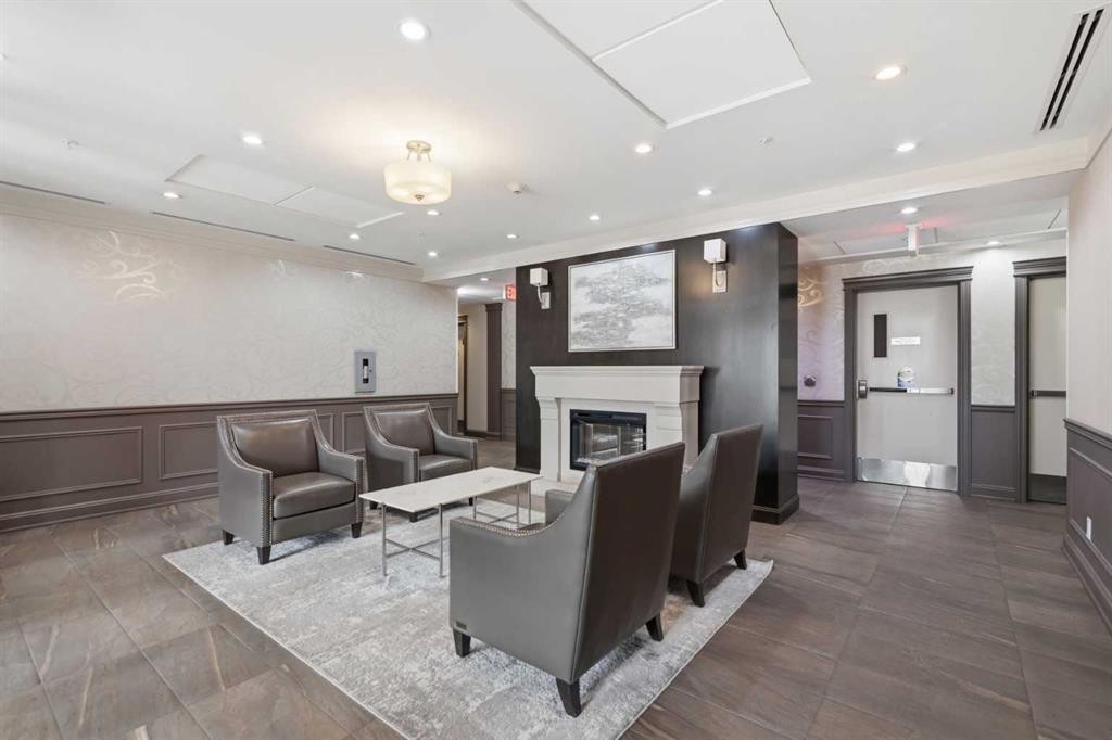 207-39 Quarry Gate Se, Calgary, AB - Indoor Photo Showing Other Room With Fireplace