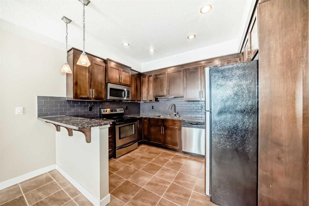 206-1005B Westmount Drive, Strathmore, AB - Indoor Photo Showing Kitchen With Stainless Steel Kitchen