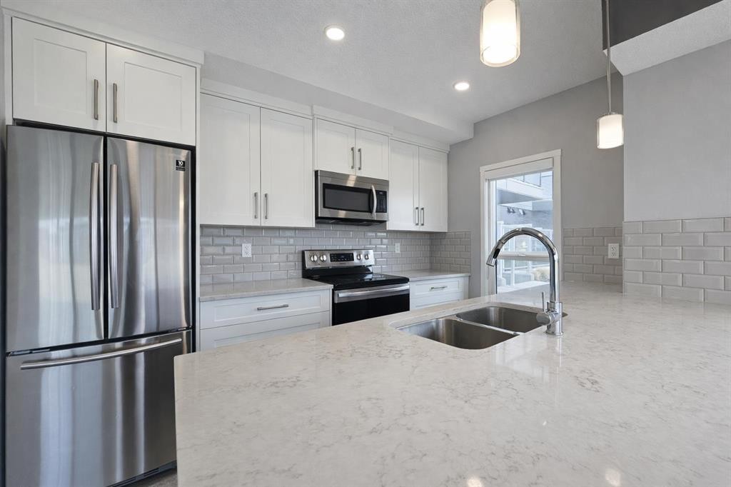 109-4150 Seton Drive Se, Calgary, AB - Indoor Photo Showing Kitchen With Stainless Steel Kitchen With Double Sink With Upgraded Kitchen
