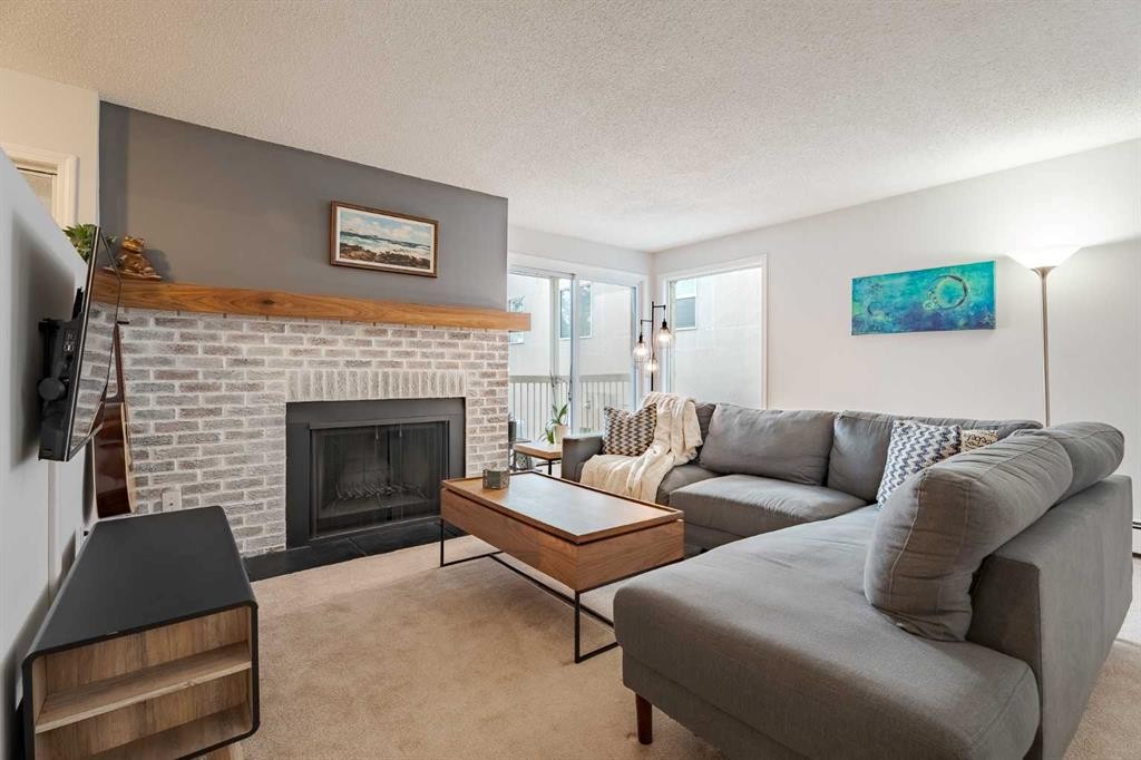 7-3402 Parkdale Boulevard Nw, Calgary, AB - Indoor Photo Showing Living Room With Fireplace
