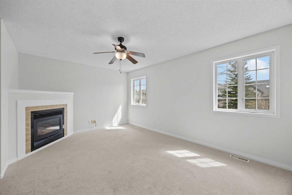 289 Hidden Spring Green Nw, Calgary, AB - Indoor Photo Showing Other Room With Fireplace