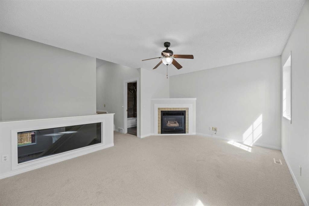 289 Hidden Spring Green Nw, Calgary, AB - Indoor Photo Showing Living Room With Fireplace
