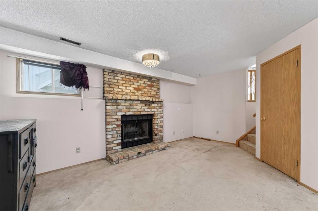 18 Falmere Way Ne, Calgary, AB - Indoor Photo Showing Other Room With Fireplace