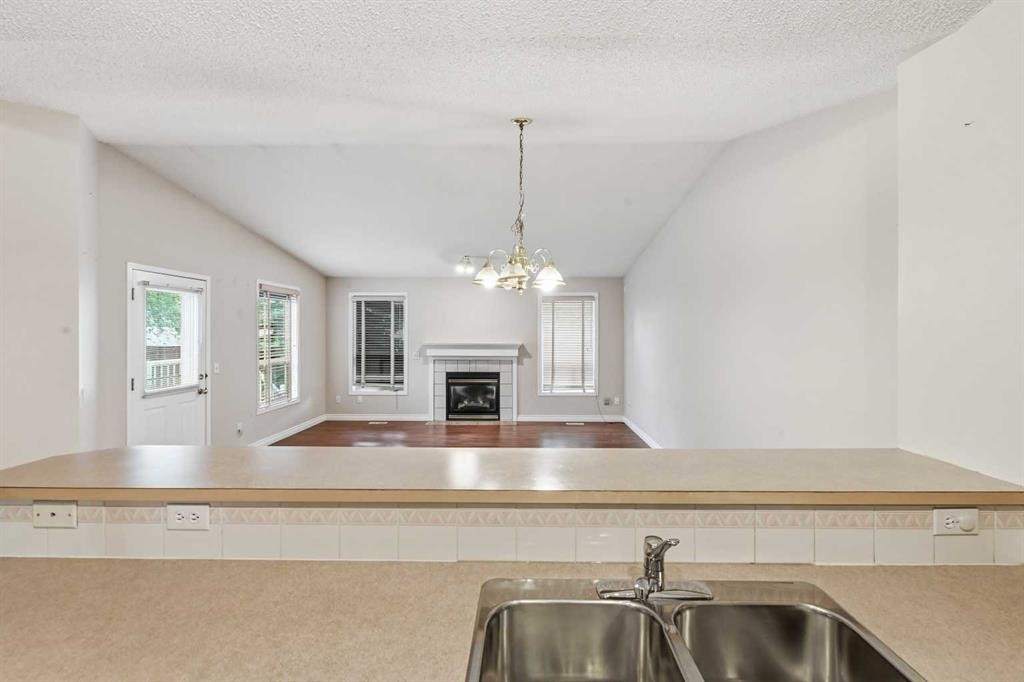 25 Tararidge Circle Ne, Calgary, AB - Indoor Photo Showing Kitchen With Fireplace With Double Sink