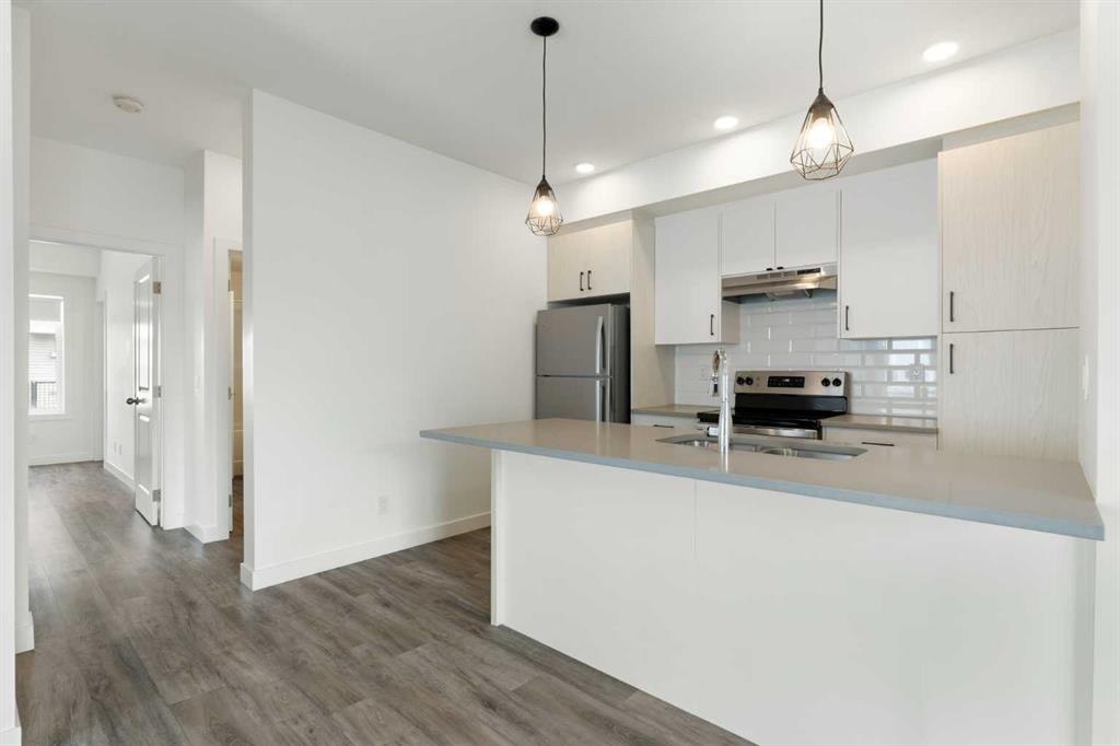 401-24 Rivercrest Drive, Cochrane, AB - Indoor Photo Showing Kitchen With Double Sink With Upgraded Kitchen