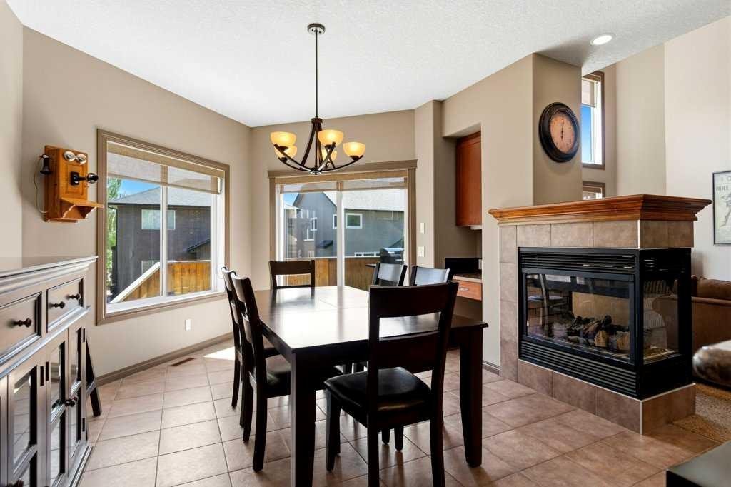 23 Aspen Stone Crescent Sw, Calgary, AB - Indoor Photo Showing Dining Room With Fireplace