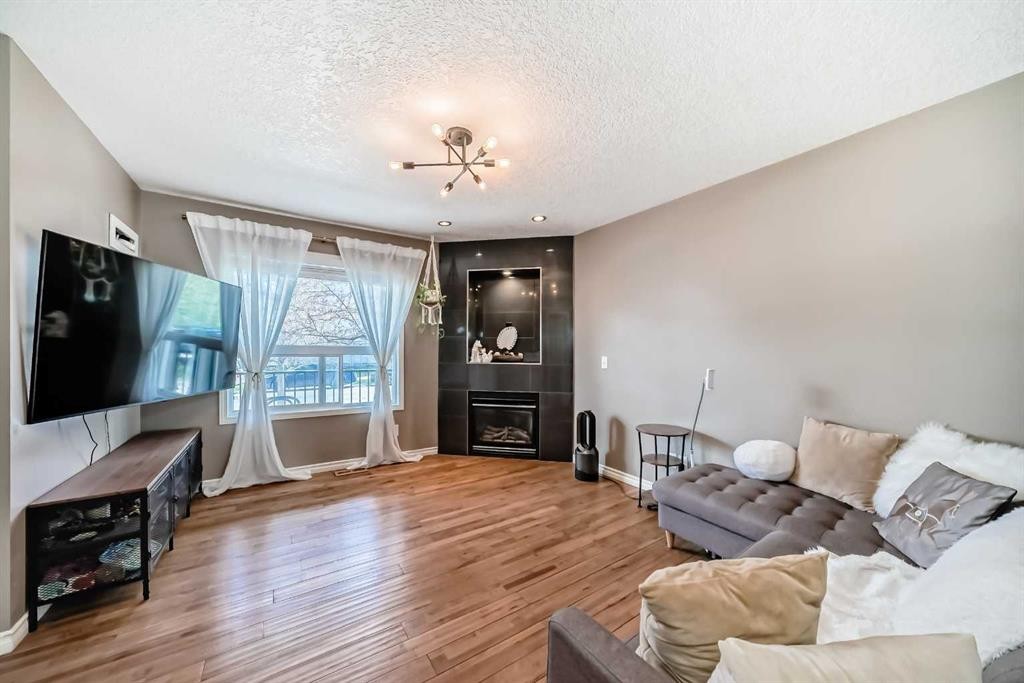 173 Eversyde Common Sw, Calgary, AB - Indoor Photo Showing Living Room With Fireplace