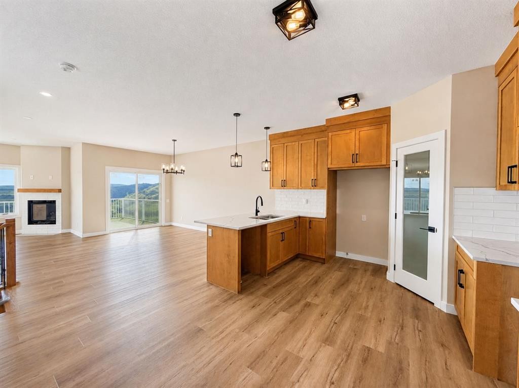 164 Ridgestone Lane, Diamond Valley, AB - Indoor Photo Showing Kitchen With Fireplace