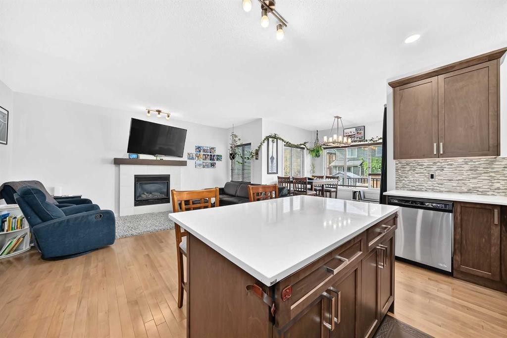 16 Sunrise Crescent, Cochrane, AB - Indoor Photo Showing Kitchen With Fireplace