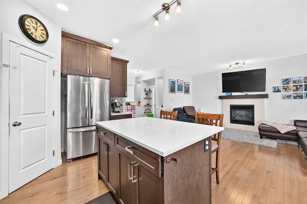 16 Sunrise Crescent, Cochrane, AB - Indoor Photo Showing Kitchen With Fireplace
