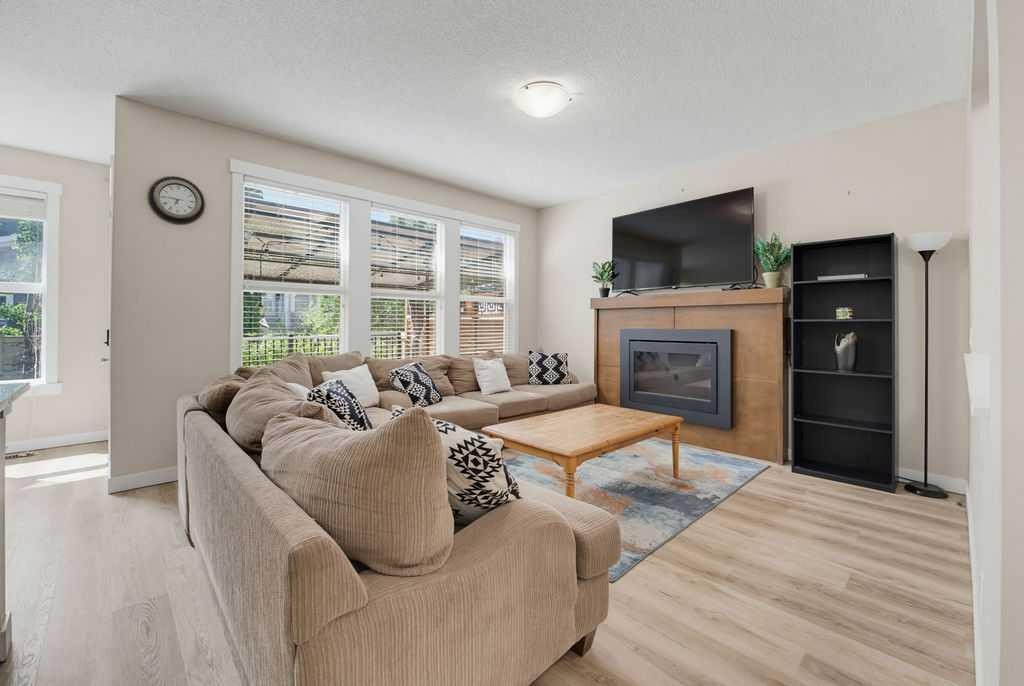 145 Sunset Manor, Cochrane, AB - Indoor Photo Showing Living Room With Fireplace