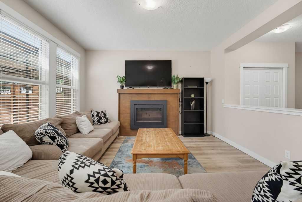 145 Sunset Manor, Cochrane, AB - Indoor Photo Showing Living Room With Fireplace