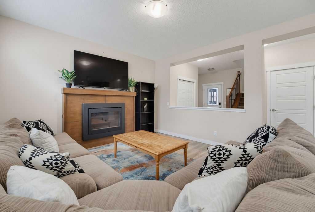145 Sunset Manor, Cochrane, AB - Indoor Photo Showing Living Room With Fireplace