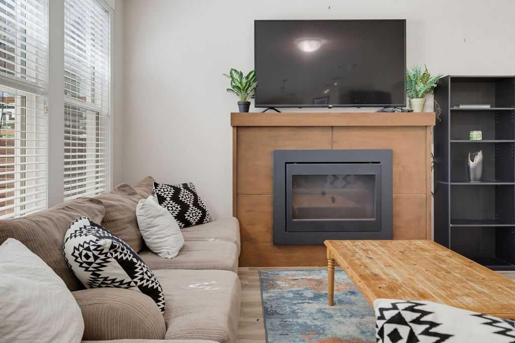 145 Sunset Manor, Cochrane, AB - Indoor Photo Showing Living Room With Fireplace