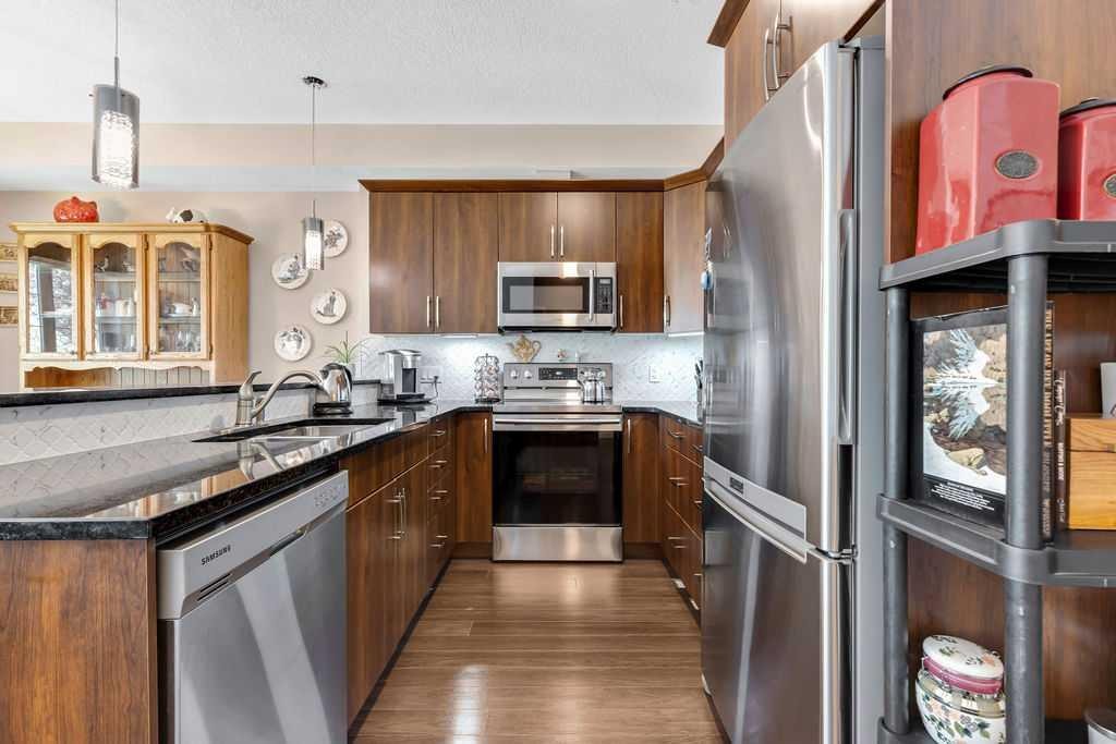 2110-15 Sunset Square, Cochrane, AB - Indoor Photo Showing Kitchen With Stainless Steel Kitchen With Double Sink