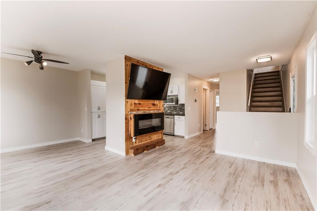 1019 Smith Avenue, Crossfield, AB - Indoor Photo Showing Other Room With Fireplace
