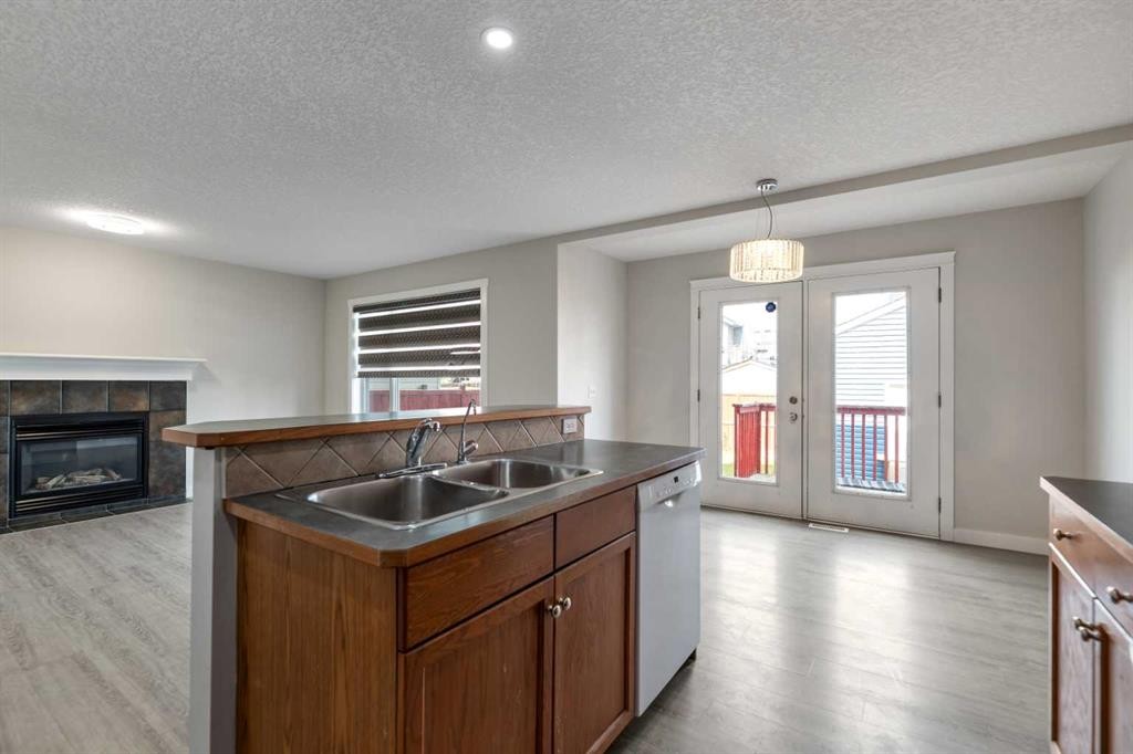 124 Saddlecrest Boulevard Ne, Calgary, AB - Indoor Photo Showing Kitchen With Fireplace With Double Sink