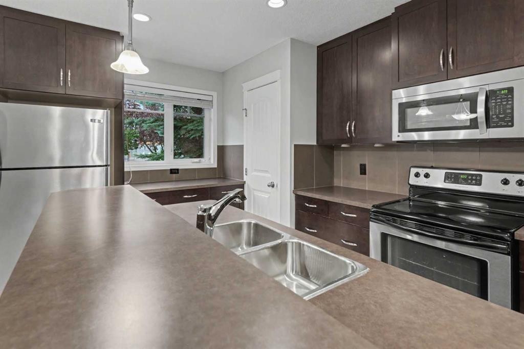 127 Prestwick Villas Se, Calgary, AB - Indoor Photo Showing Kitchen With Stainless Steel Kitchen With Double Sink