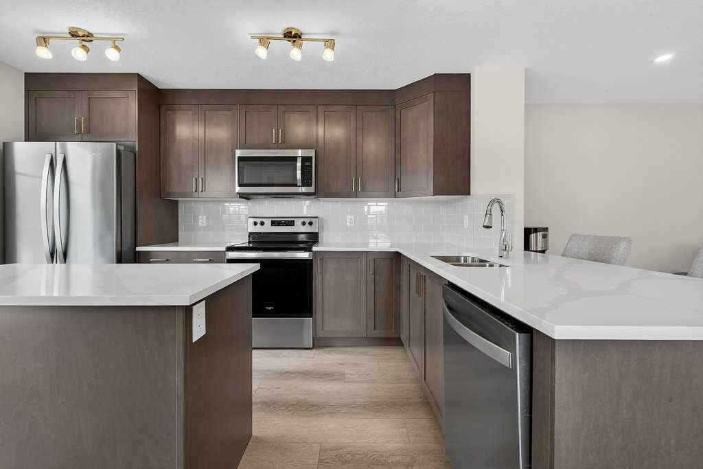 709-474 Seton Circle Se, Calgary, AB - Indoor Photo Showing Kitchen With Stainless Steel Kitchen With Double Sink With Upgraded Kitchen