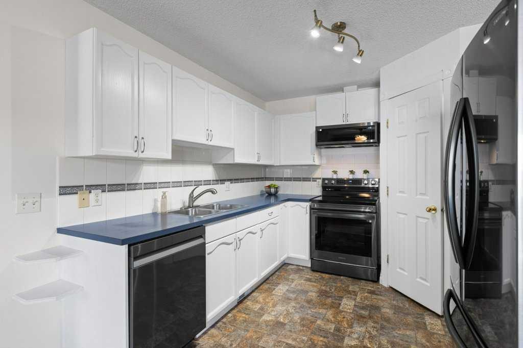 202 Willowbrook Close Nw, Airdrie, AB - Indoor Photo Showing Kitchen With Double Sink