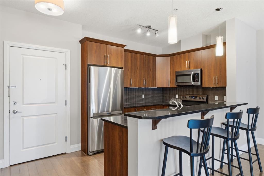 2208-15 Sunset Square, Cochrane, AB - Indoor Photo Showing Kitchen With Stainless Steel Kitchen