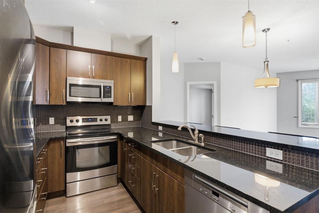 2208-15 Sunset Square, Cochrane, AB - Indoor Photo Showing Kitchen With Stainless Steel Kitchen With Double Sink With Upgraded Kitchen