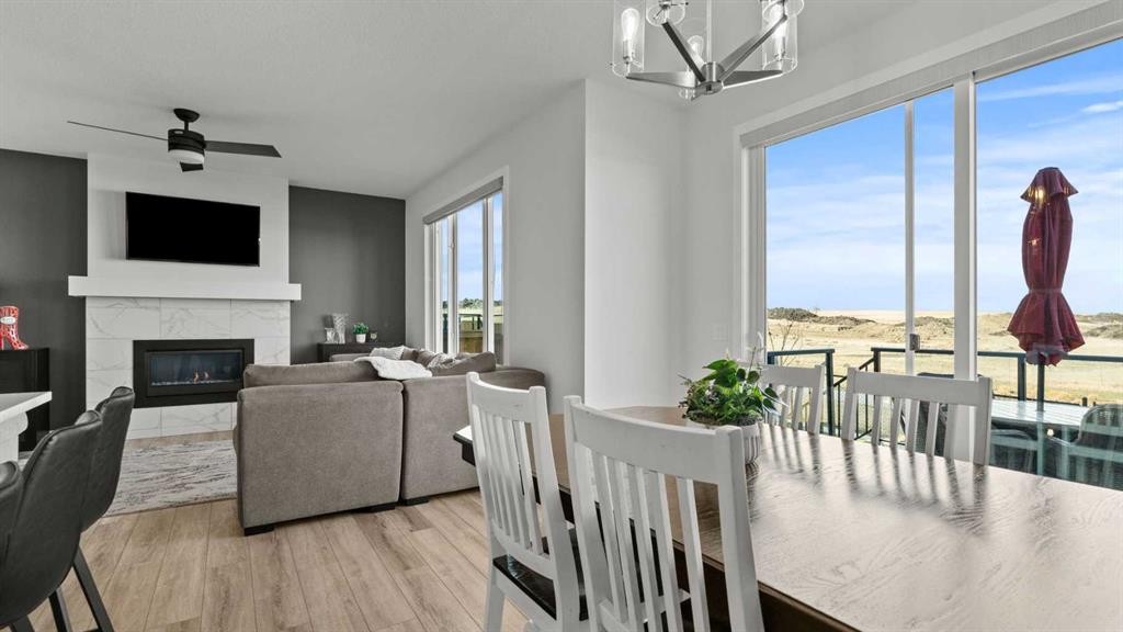 152 Threepoint Cove, Okotoks, AB - Indoor Photo Showing Dining Room With Fireplace