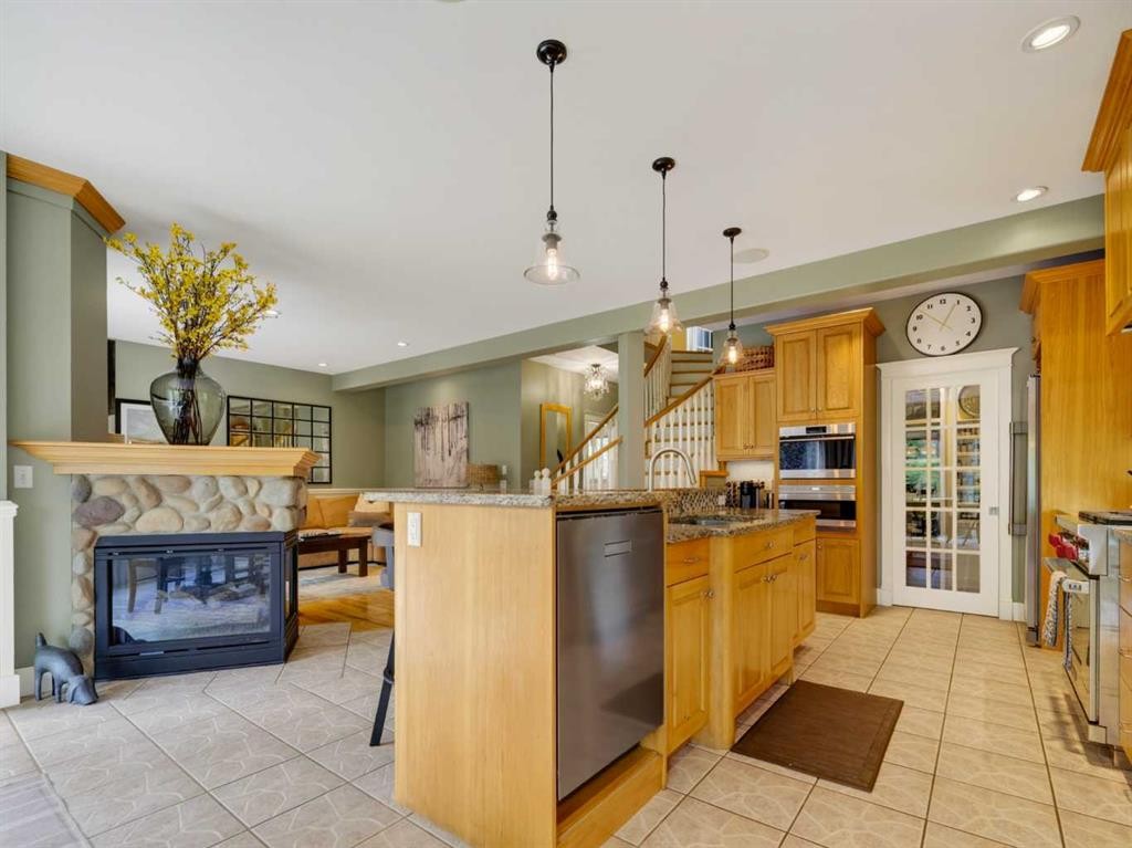 126 West Terrace Point, Cochrane, AB - Indoor Photo Showing Kitchen With Fireplace