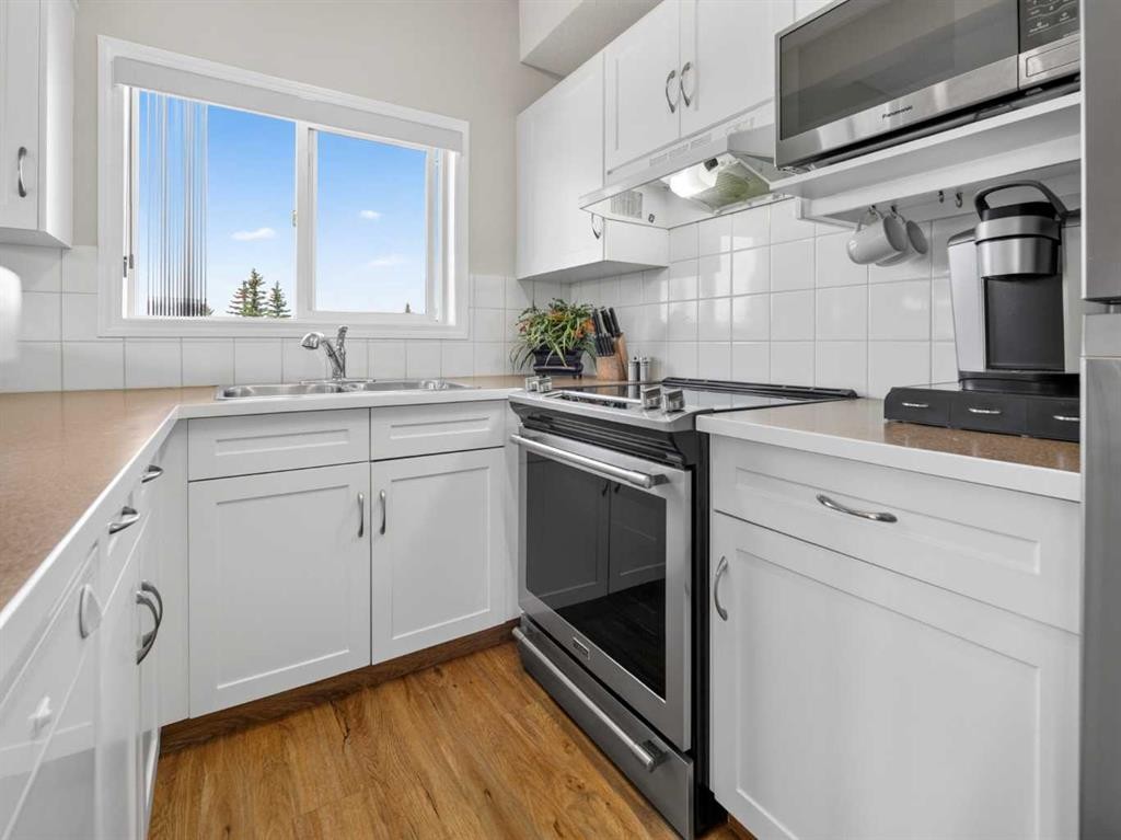 201-72 Quigley Drive, Cochrane, AB - Indoor Photo Showing Kitchen With Double Sink
