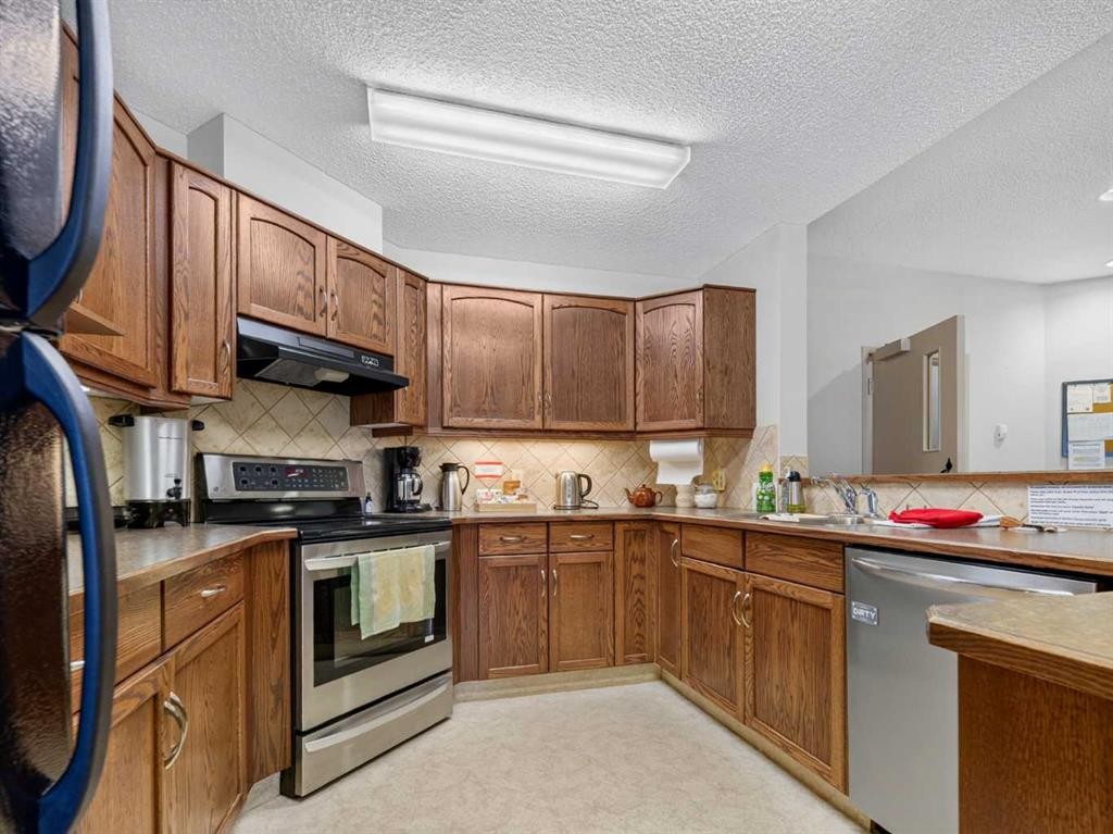 201-72 Quigley Drive, Cochrane, AB - Indoor Photo Showing Kitchen With Double Sink