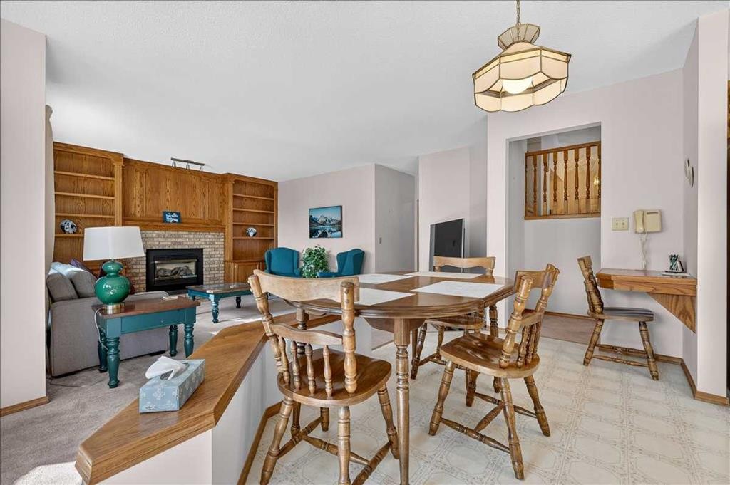 105 Christie Knoll Heights Sw, Calgary, AB - Indoor Photo Showing Dining Room With Fireplace