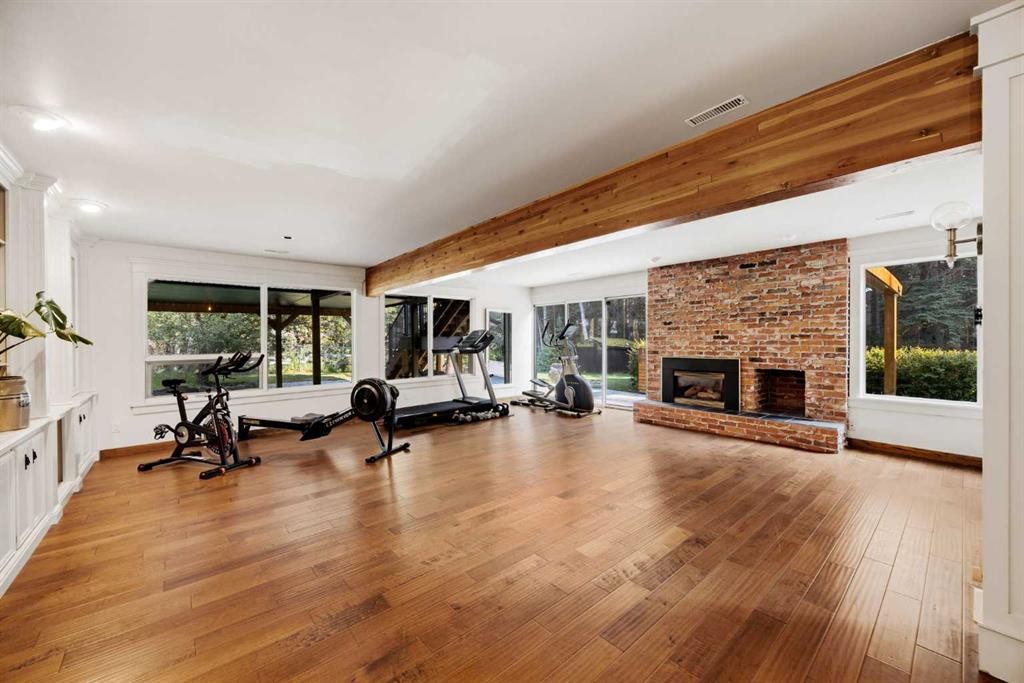 15 Elbow River Point, Rural Rocky View County, AB - Indoor Photo Showing Gym Room With Fireplace