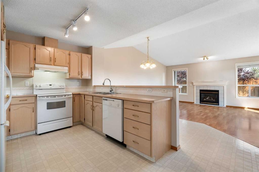 77 Tararidge Circle Ne, Calgary, AB - Indoor Photo Showing Kitchen With Fireplace