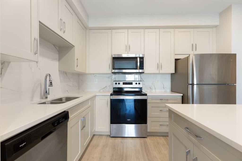 202-150 Shawnee Square Sw, Calgary, AB - Indoor Photo Showing Kitchen With Stainless Steel Kitchen With Double Sink With Upgraded Kitchen