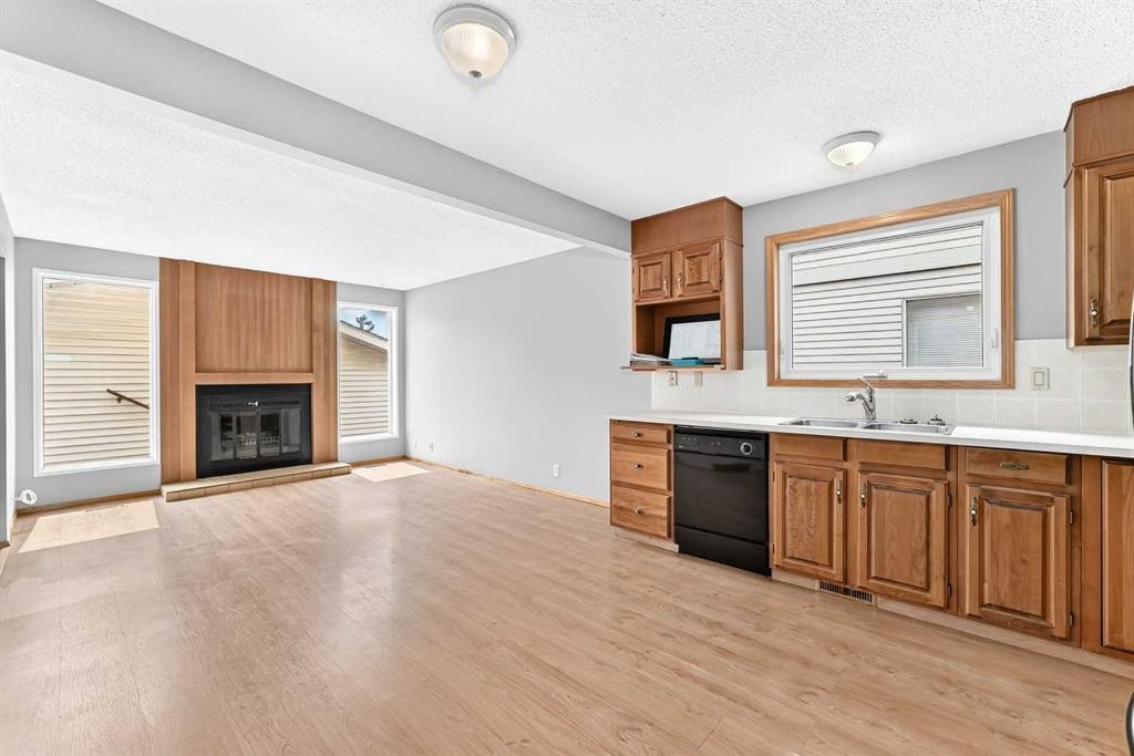 128 Erin Woods Drive Se, Calgary, AB - Indoor Photo Showing Kitchen With Fireplace With Double Sink